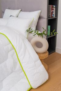 Kołdra BAMBOO 155x200 AMZ z białym poszyciem i zieloną lamówką w aranżacji łóżka